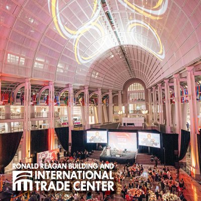 A large formal event fills the Ronald Reagan Building’s grand atrium beneath dramatic lighting.