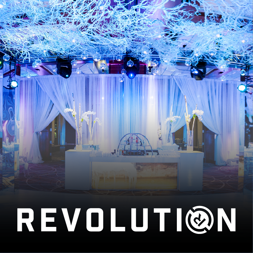 Elegant event space with white draping, glowing blue lights and decorative ceiling installations.