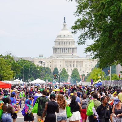 Crowds attend a lively festival on Pennsylvania Avenue, with the U.S. Capitol in the background. 