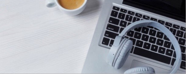 Casque d'écoute posé sur un clavier d'ordinateur
