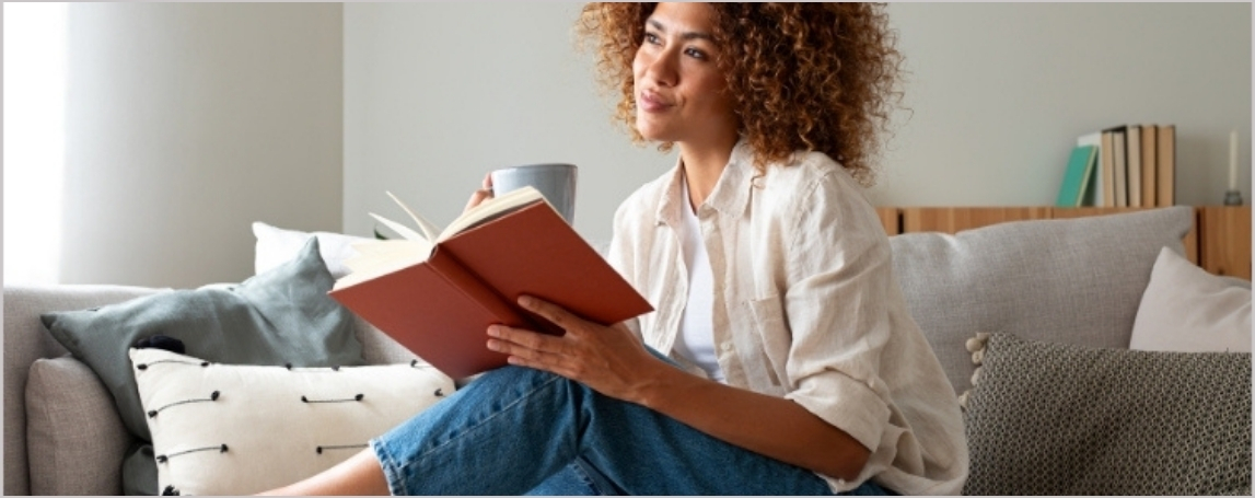 Femme souriante tenant un livre entrouvert