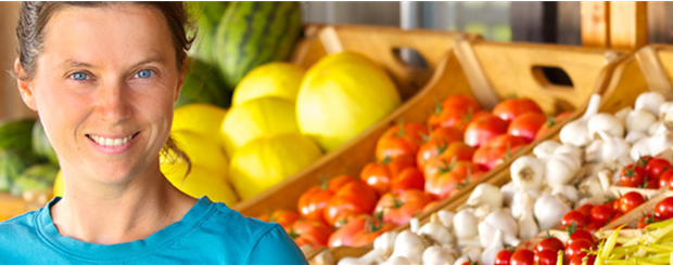 Femme avec étalage de légumes