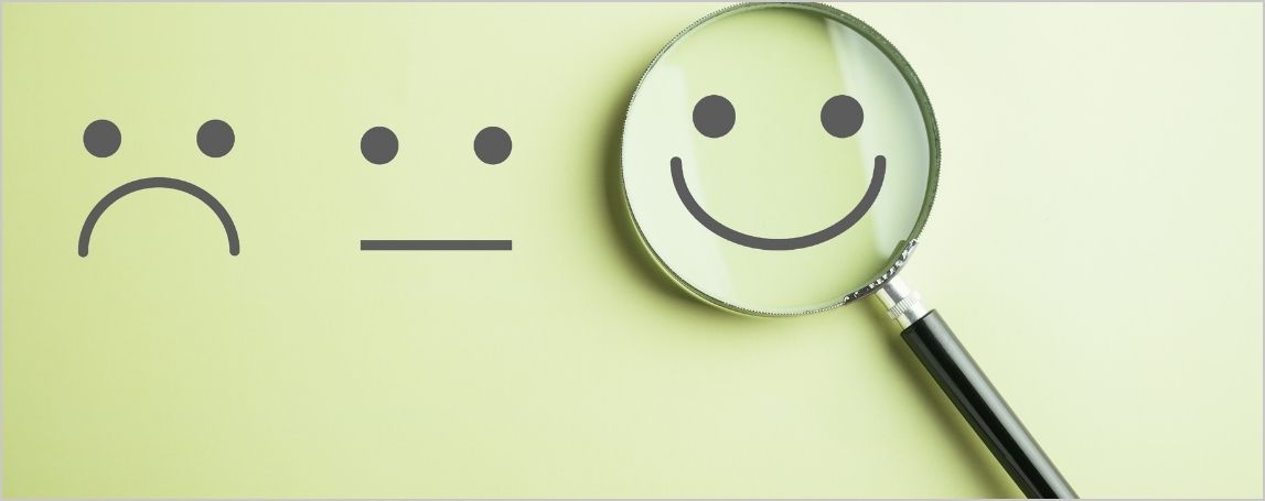 &Eacute;motic&ocirc;ne d'un visage souriant sous une loupe