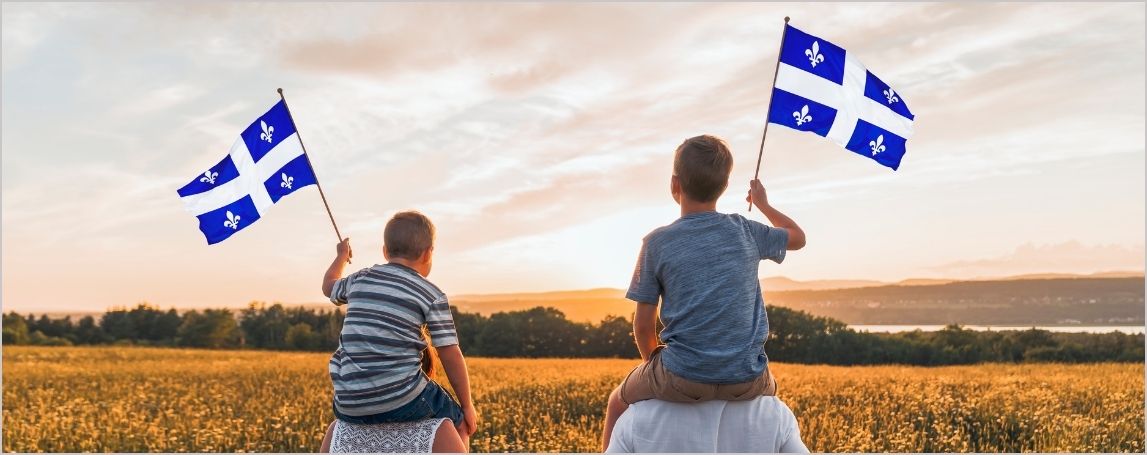 Enfants regardant un coucher de soleil en agitant des drapeaux du Québec