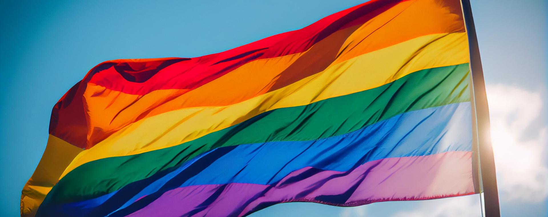 Un drapeau arc-en-ciel qui flotte au vent.