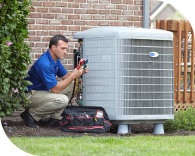 Tech tuning up an outdoor AC unit