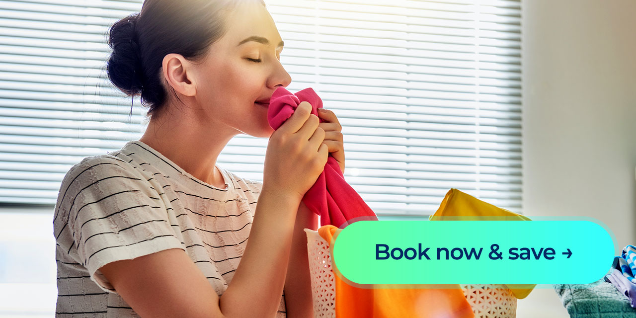 A woman holds a freshly laundered shirt near a laundry basket with a “Book now & save” button overlay