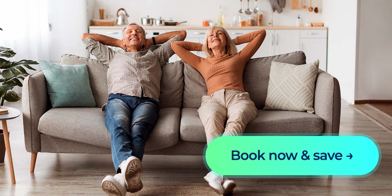 A couple relaxing on a couch in a bright home with a “Book now & save” button.