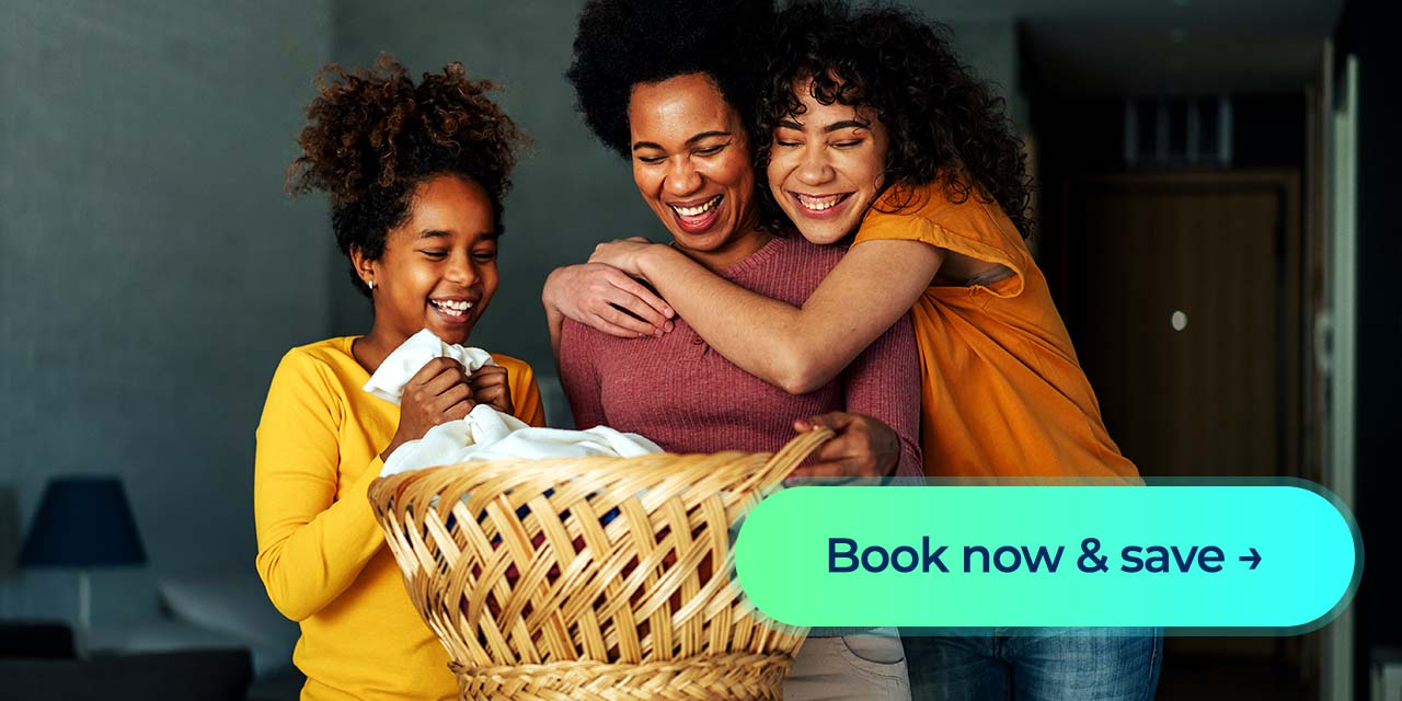 A woman and two children smile over a laundry basket with a “Book now & save” button.