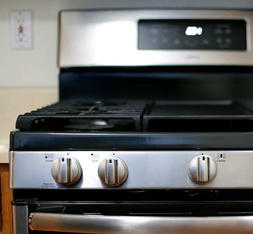 Close-up view of a stainless steel gas range with front control knobs