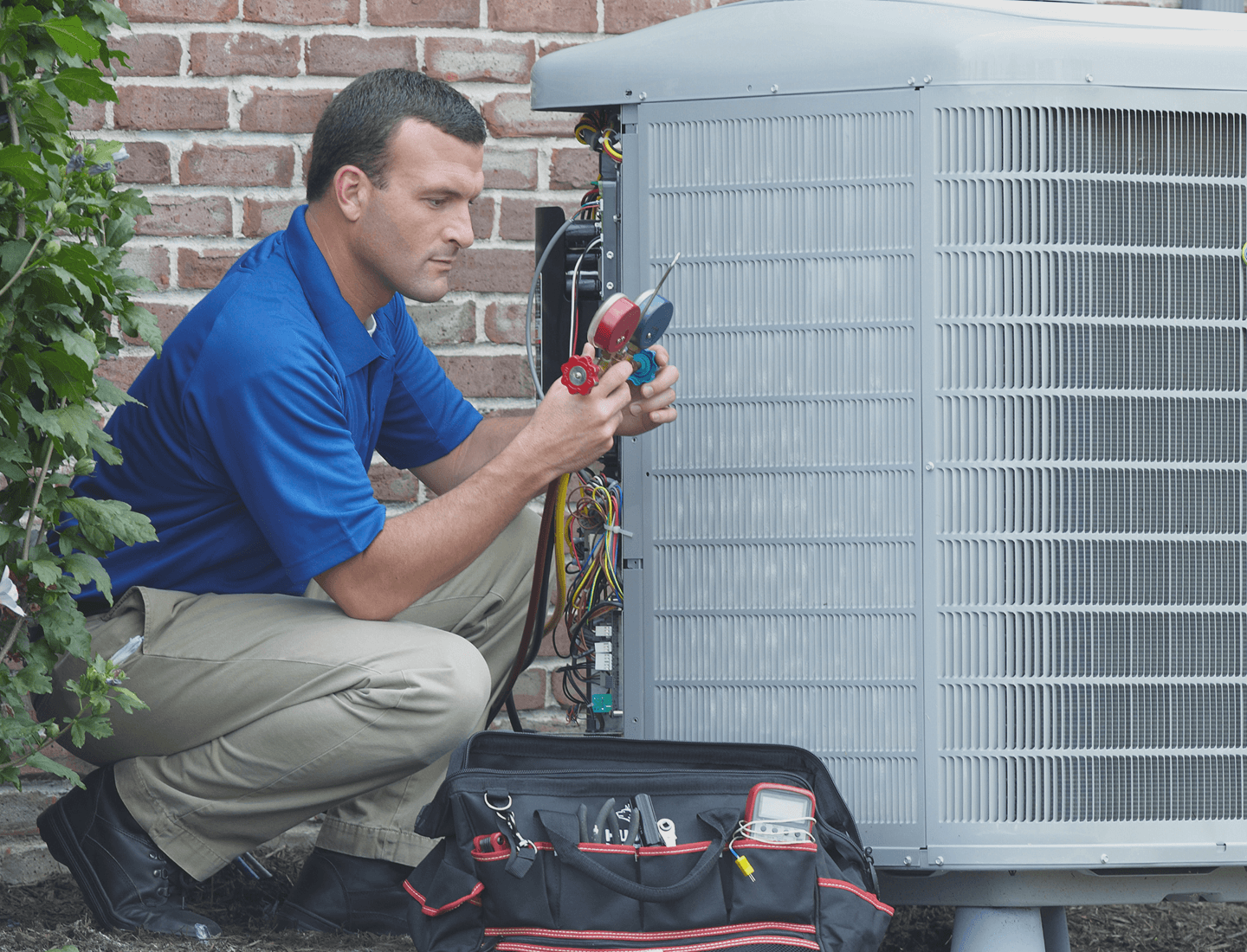 A Sears Home Services technician performs maintenance on an outdoor A/C unit. 
