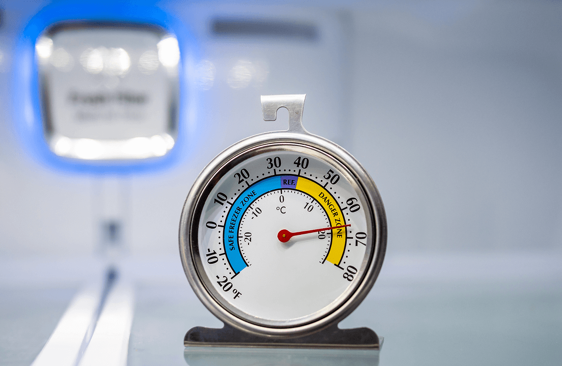 A thermometer on a shelf within a fridge