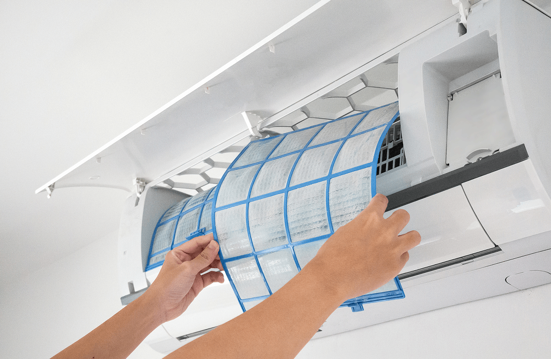 A person taking out a filter from an AC unit