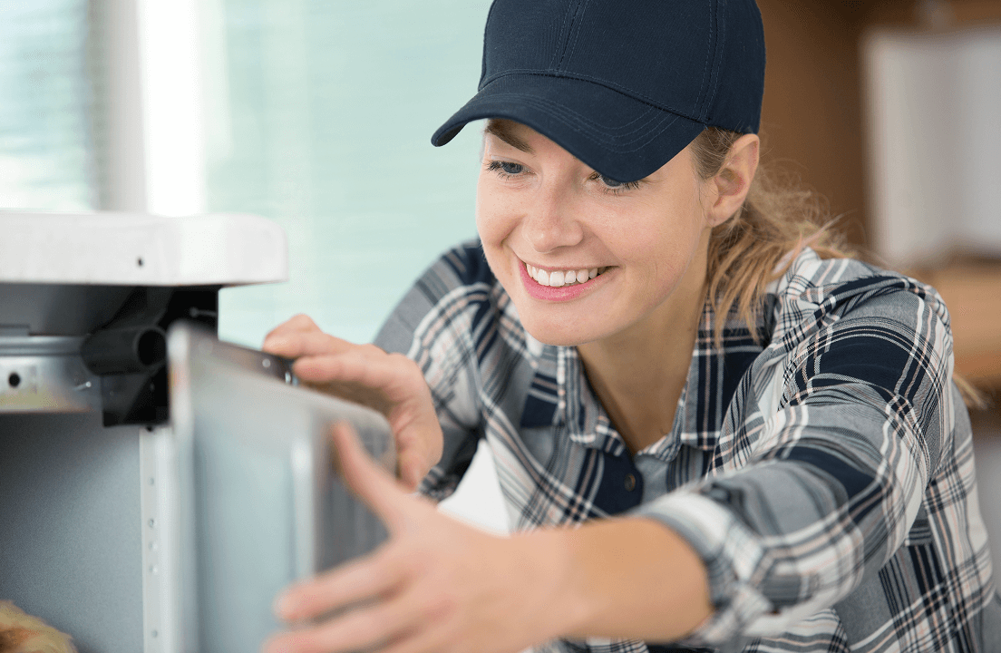 A woman attempting to repair a dishwasher door