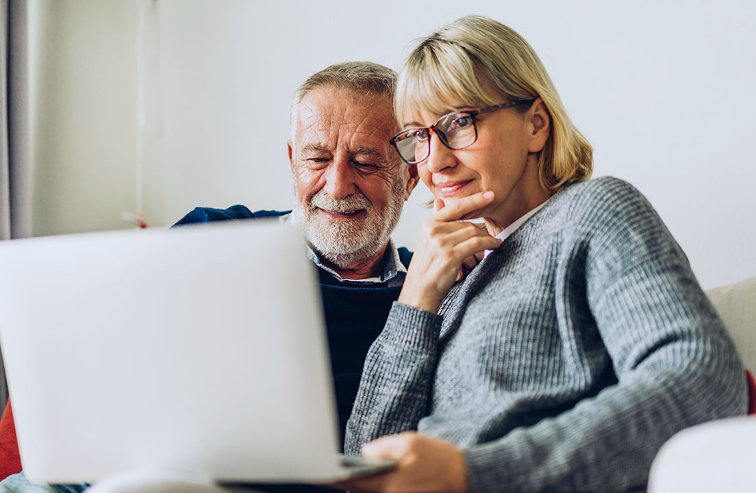 A man and woman look over home warranty options on their laptop