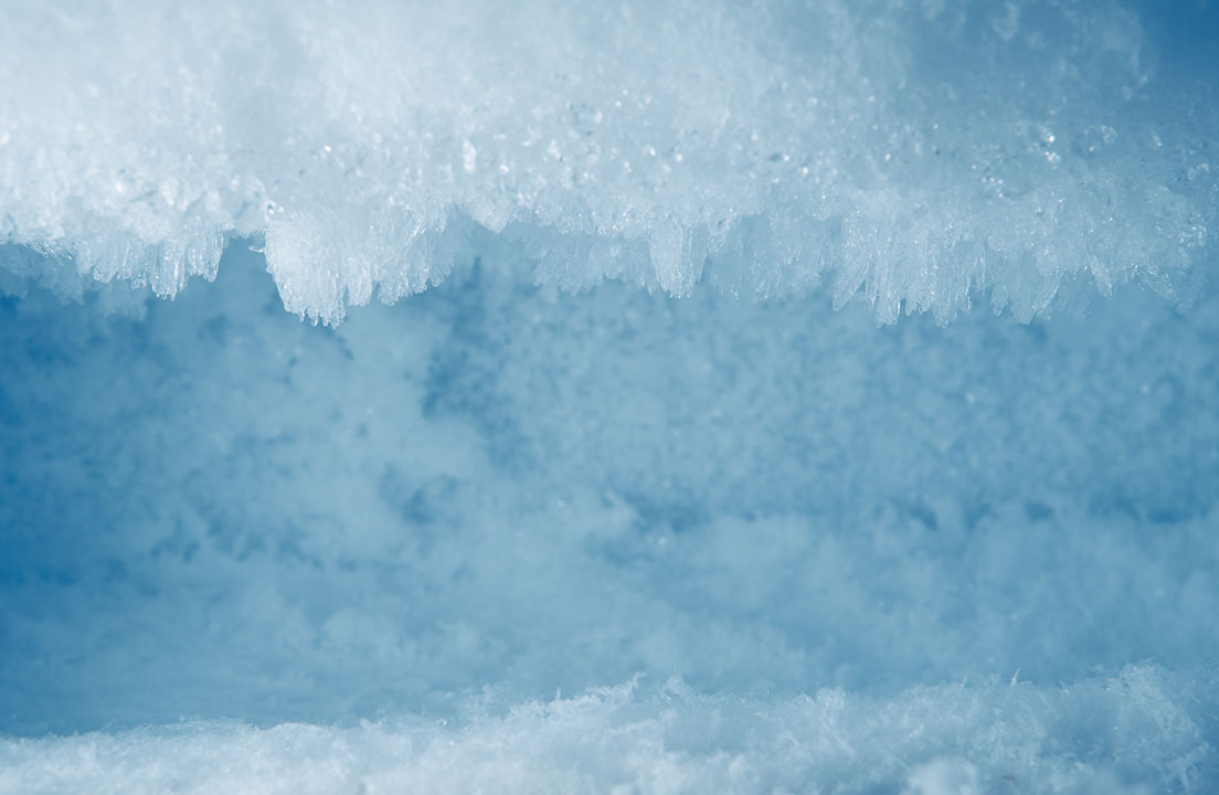 Close-up view of thick frost crystals and icy buildup covering the inside of a freezer