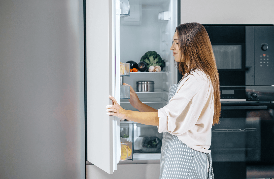 A woman opening a refrigerator