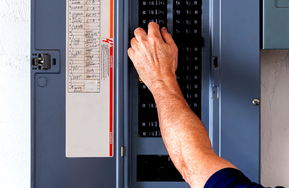 Hand resetting a circuit breaker inside an electrical panel