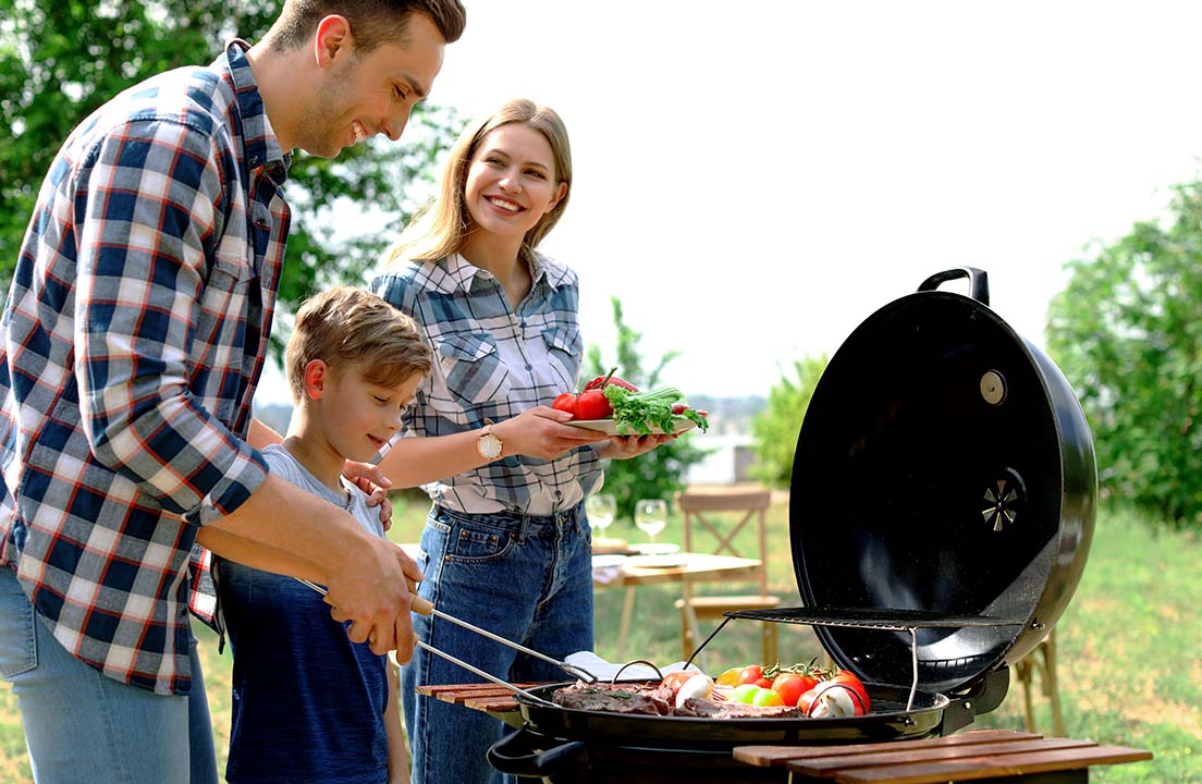 Family grilling together outdoors on a sunny day