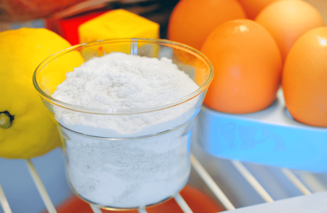 Baking soda in a jar next to fruits in a fridge
