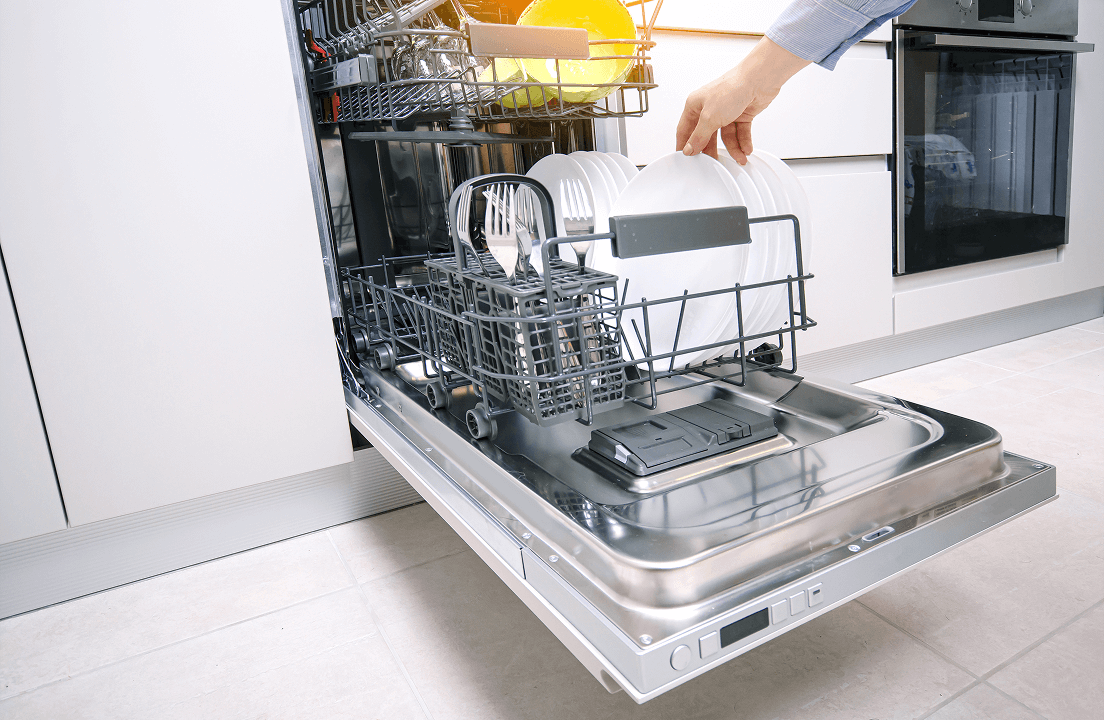 A person grabbing a white dish from a stainless steel dishwasher