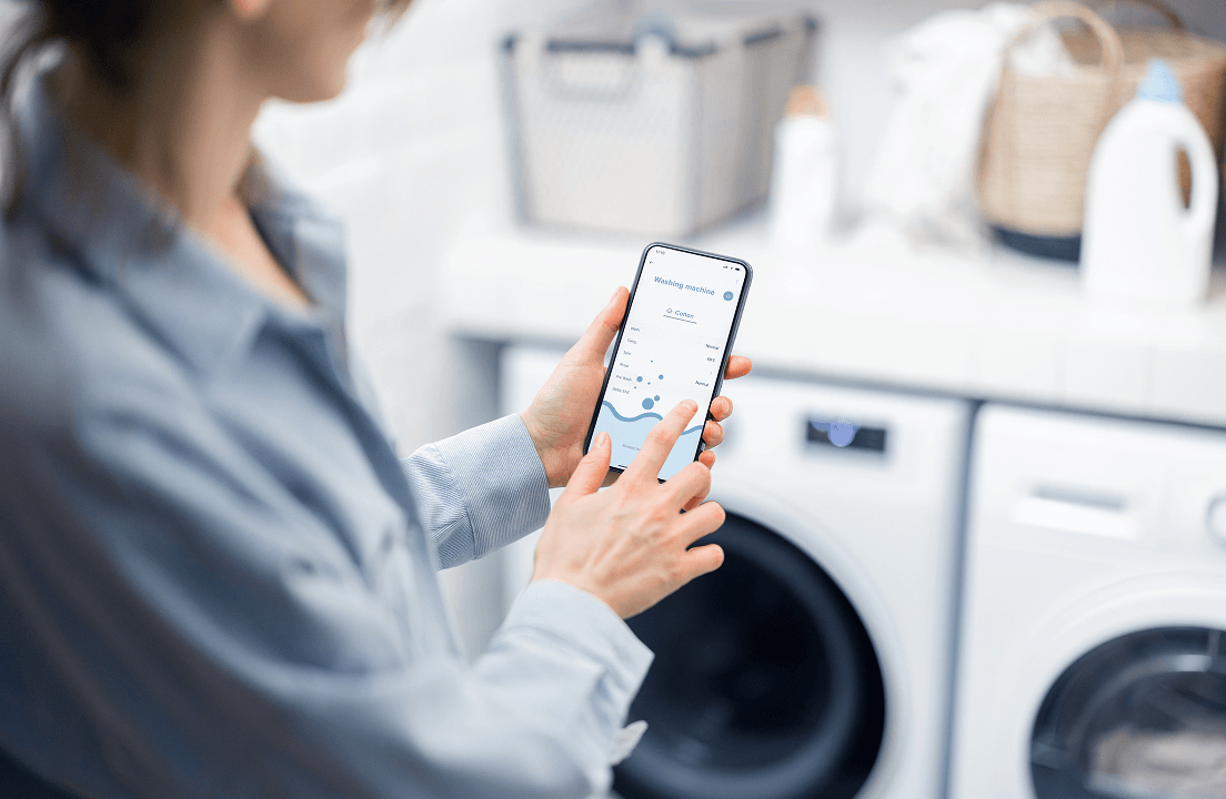 A woman selecting a washing machine cycle to use from her smart phone