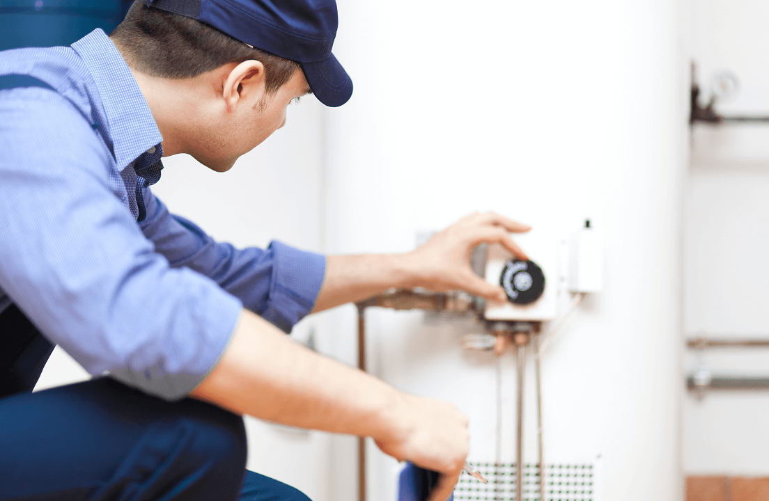 A Sears Technician adjusting a dial on a furnace