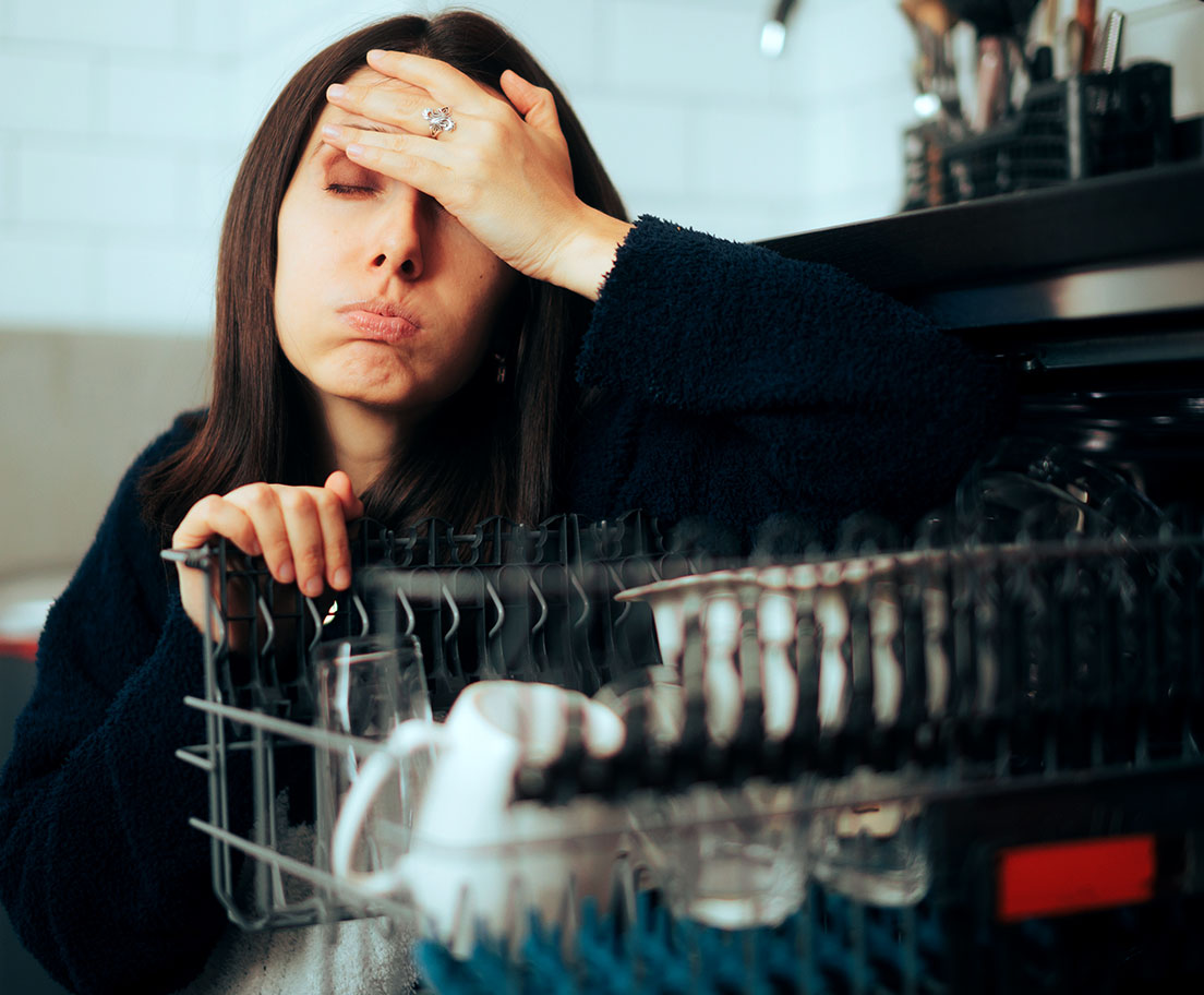 A homeowner looks at their appliances while wondering why everyday performance like cleaning, cooling, and drying starts to slip