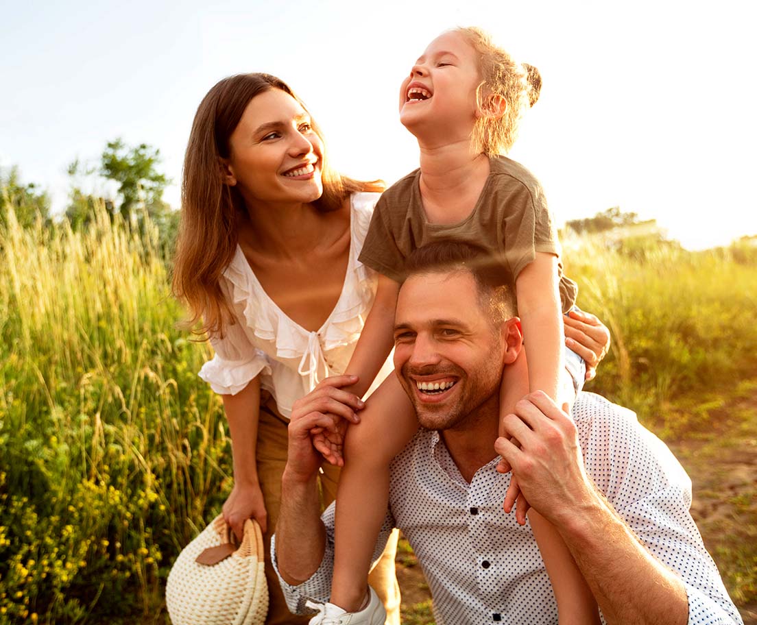 Family enjoying a sunny outdoor walk together in a grassy field