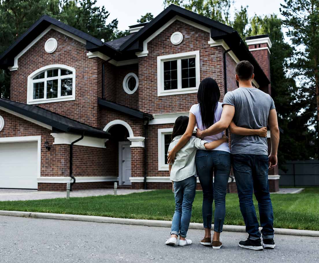 A family looking at their house from the street