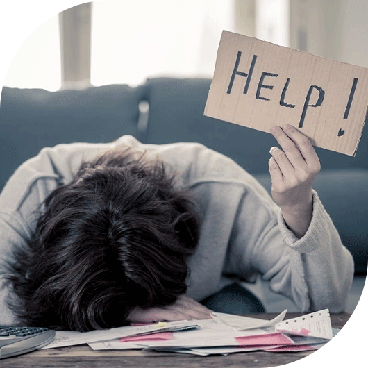 Person overwhelmed with bills holding a sign that says 'Help!'
