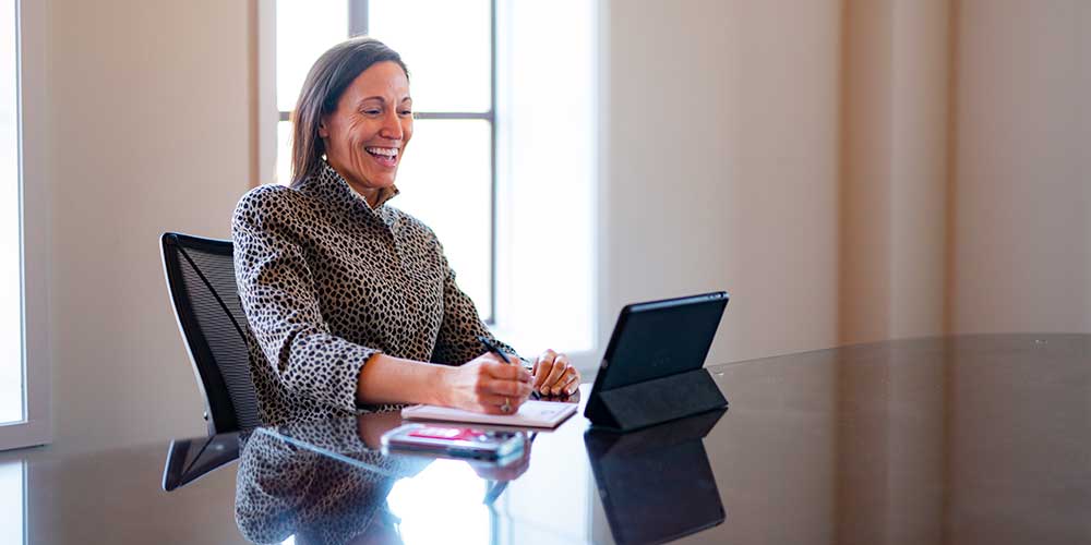 Business woman smiling at tablet screen