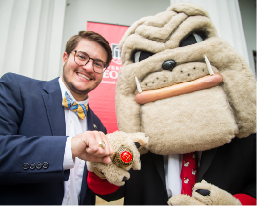 Hairy Dawg and student wearing UGA class rings.
