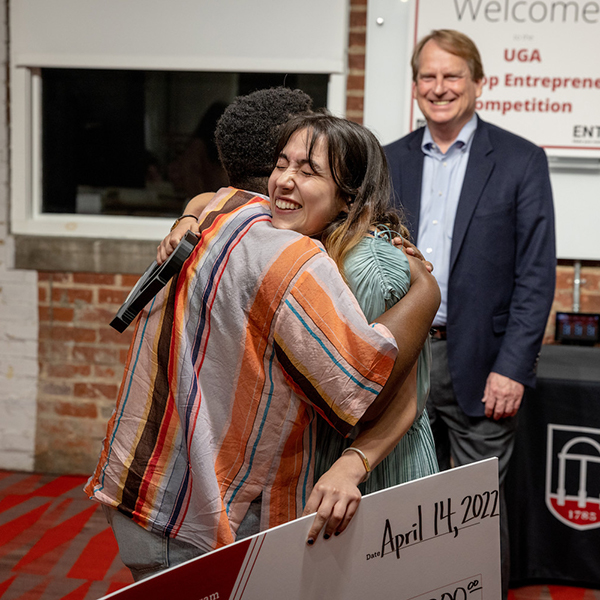 Two student entrepreneurs hug after a pitch contest hosted by Terry College. 