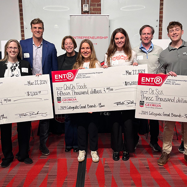 Winners of the Collegiate Great Brands contest stand in a group with their giant novelty prize checks at Studio 225