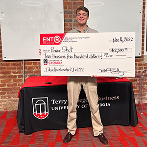 Terry student Charlie Gaddy stands with a giant prize check in Studio 225