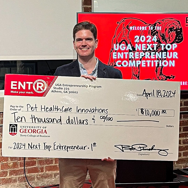 J.D. Thomerson, winner of UGA's Next Top Entrepreneur pitch contest with a novelty check. 