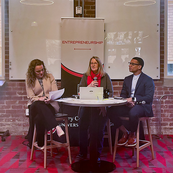 Margaret Christ sits with EY's Jennifer Price and Terrance Griffin as they speak to a crowd at Studio 225.