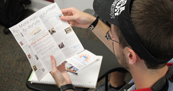 Male student reading homeless shelter brochure