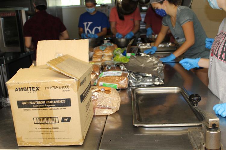 Students wearing face coverings pack food