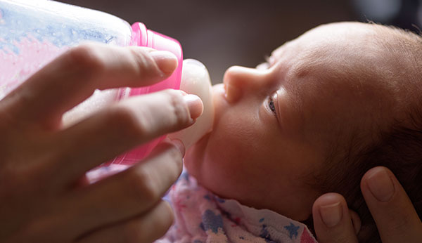 image of baby being fed from a bottle